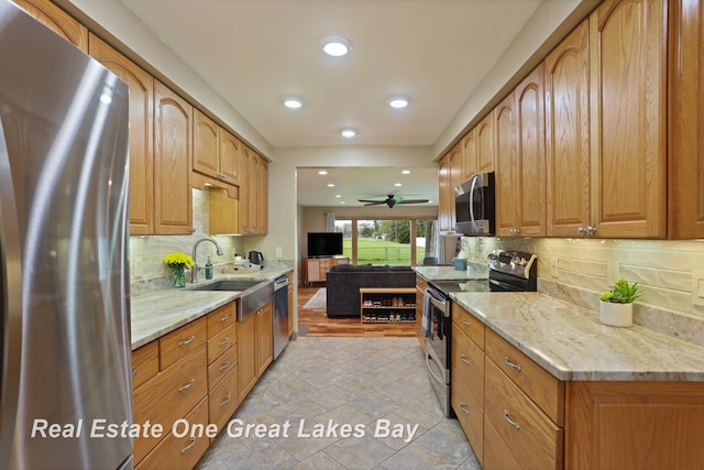1416 Airfield Ln, Midland, MI 48642 - kitchen with stainless steel appliances, a sink, light stone counters, backsplash, and recessed lighting