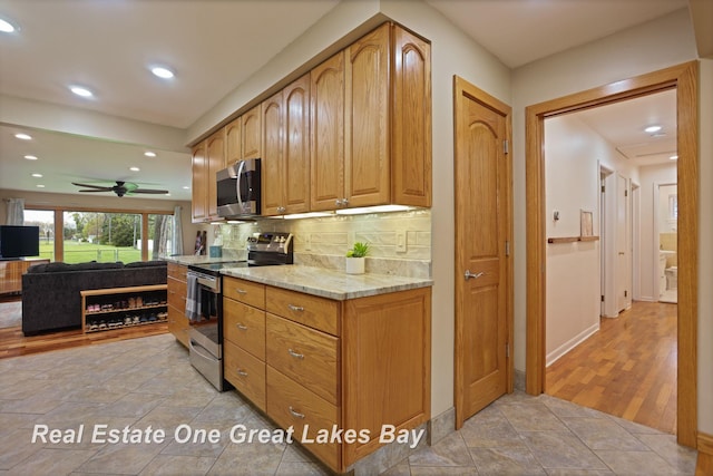 1416 Airfield Ln, Midland, MI 48642 - kitchen featuring stainless steel appliances, tasteful backsplash, light stone countertops, recessed lighting, and a ceiling fan