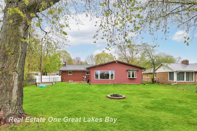 1416 Airfield Ln, Midland, MI 48642 - back of property featuring an outdoor fire pit, a chimney, and brick siding