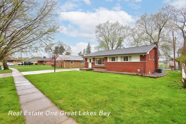 1416 Airfield Ln, Midland, MI 48642 - ranch-style home with brick siding, a chimney, a front yard, and concrete driveway