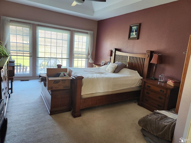 bedroom with light colored carpet, access to outside, and ceiling fan