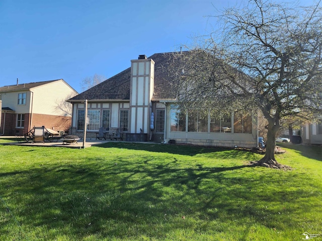 back of property with an outdoor fire pit, a chimney, and a yard
