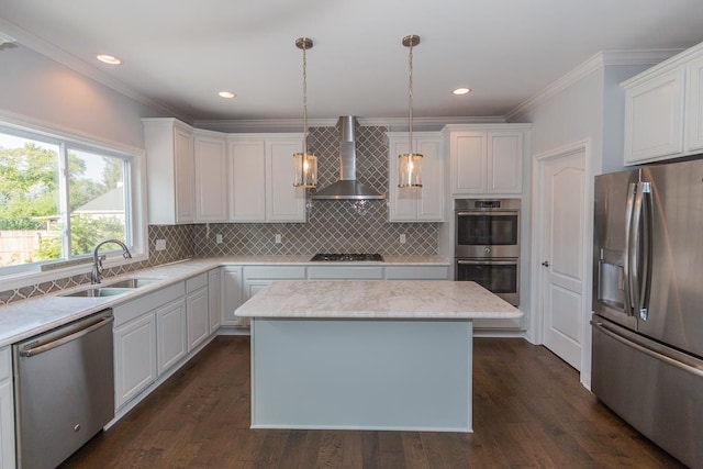 kitchen featuring appliances with stainless steel finishes, wall chimney exhaust hood, ornamental molding, a sink, and white cabinetry