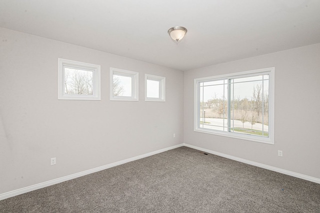 carpeted empty room featuring healthy amount of natural light and baseboards