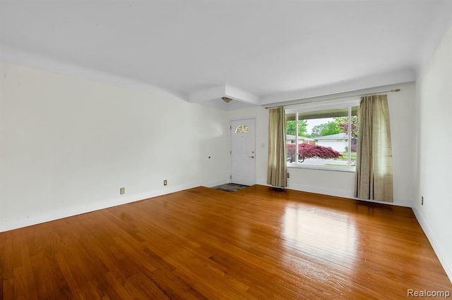 unfurnished room featuring wood finished floors and baseboards