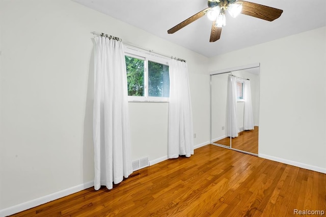 unfurnished bedroom with wood finished floors, baseboards, and ceiling fan