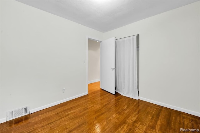 unfurnished bedroom with a closet, baseboards, and wood finished floors