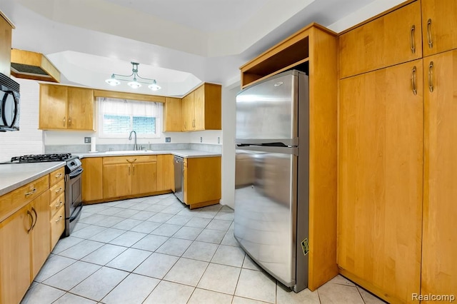 kitchen with stainless steel appliances, a sink, light countertops, and light tile patterned floors