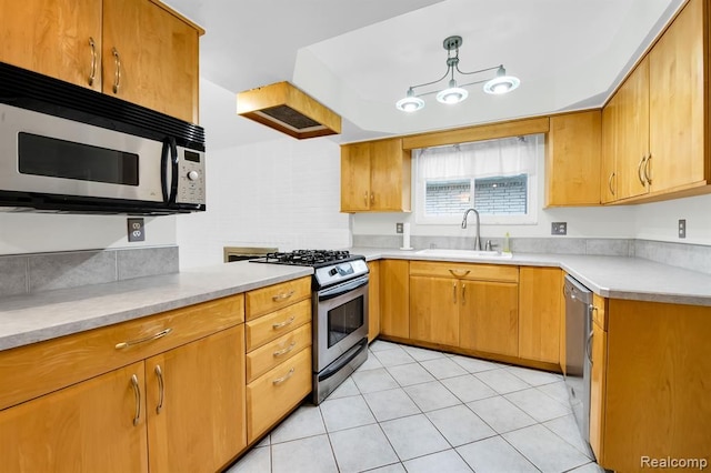 kitchen featuring a sink, appliances with stainless steel finishes, light countertops, and light tile patterned flooring