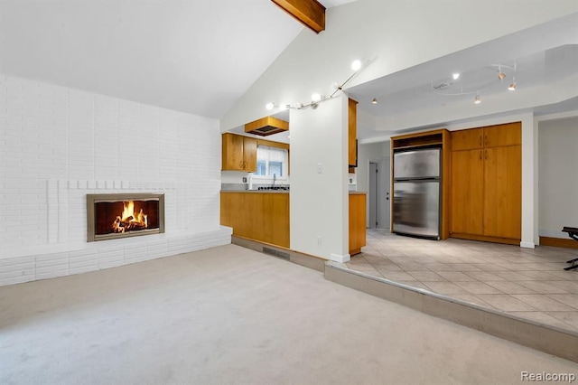 unfurnished living room featuring light carpet and a brick fireplace