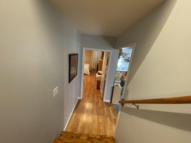 hall featuring light wood-style floors and baseboards