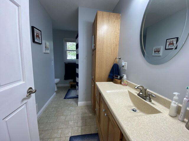 bathroom with vanity, toilet, and baseboards
