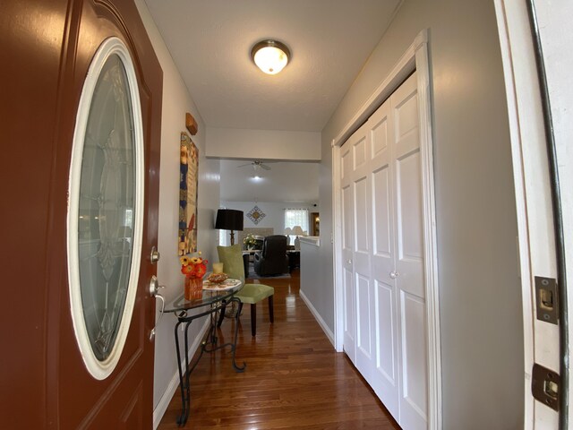 entryway with dark wood finished floors, baseboards, and a ceiling fan