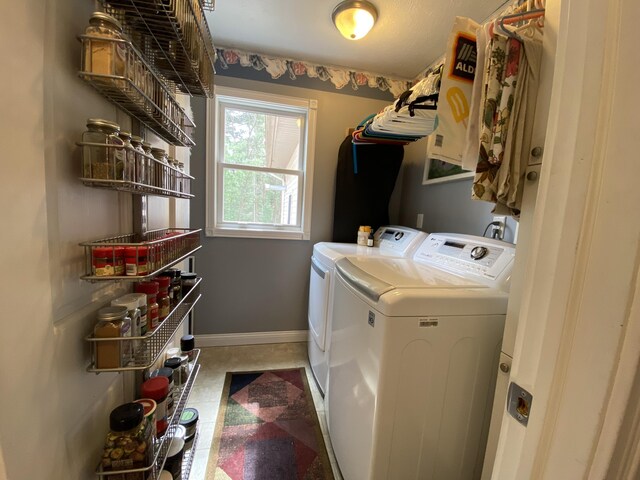 laundry room with washer and dryer and baseboards