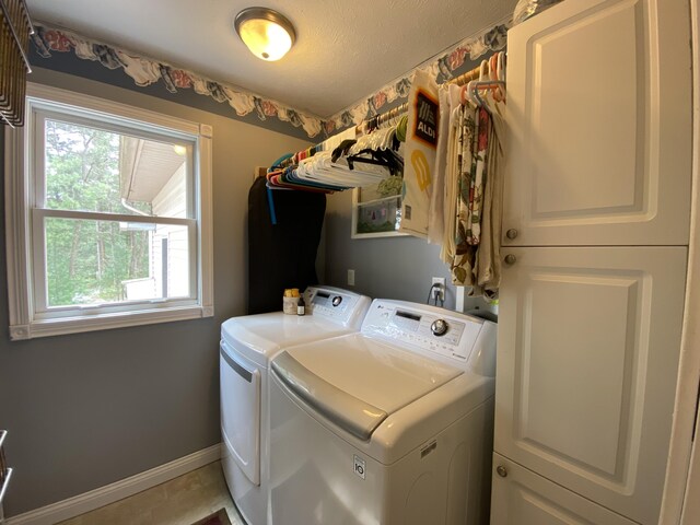 laundry room with separate washer and dryer, plenty of natural light, cabinet space, and baseboards