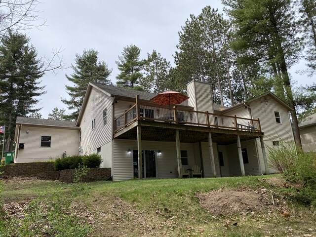 rear view of house with a deck and a chimney