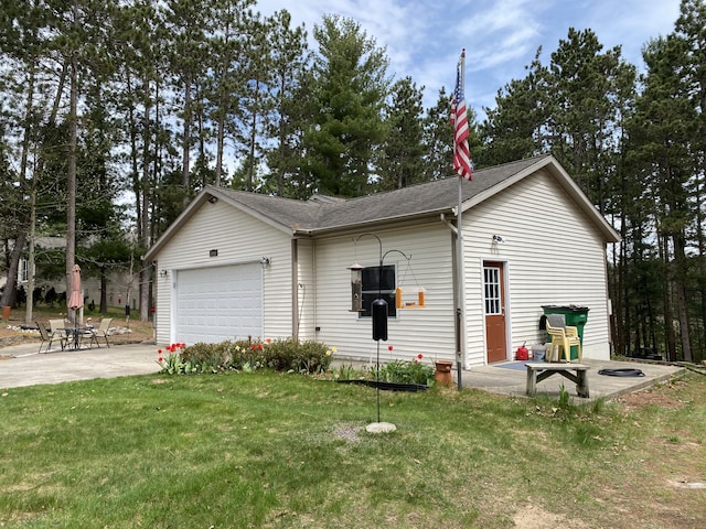 view of front of home featuring an attached garage, concrete driveway, a front yard, and roof with shingles