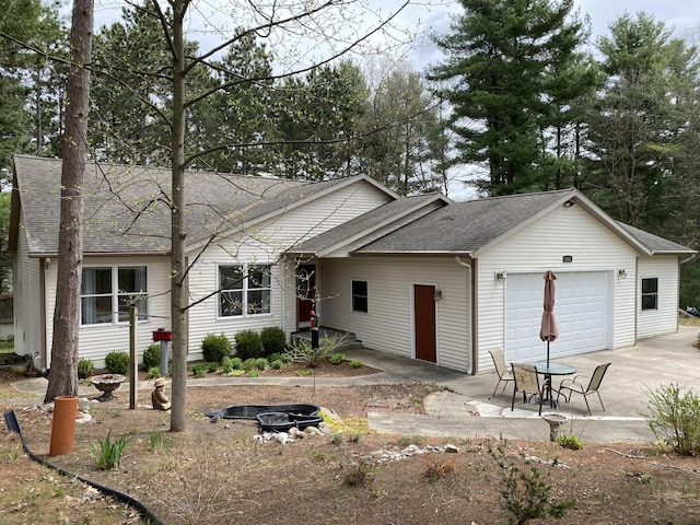 single story home featuring concrete driveway, a garage, and a shingled roof