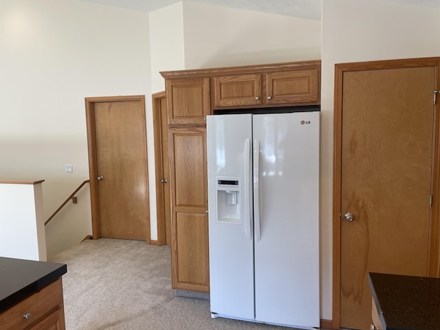 1712 Lisa Dr SW, Byron Center, MI 49315 - kitchen featuring white refrigerator with ice dispenser, light colored carpet, brown cabinetry, and dark countertops