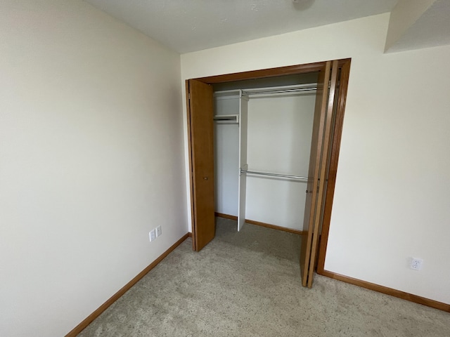 1712 Lisa Dr SW, Byron Center, MI 49315 - unfurnished bedroom featuring light carpet, baseboards, and a closet
