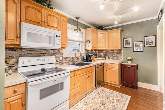 kitchen with white appliances, a sink, wood finished floors, light countertops, and crown molding