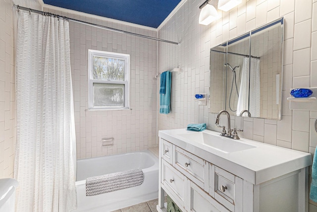 bathroom featuring shower / tub combo with curtain, tile patterned flooring, vanity, and tile walls