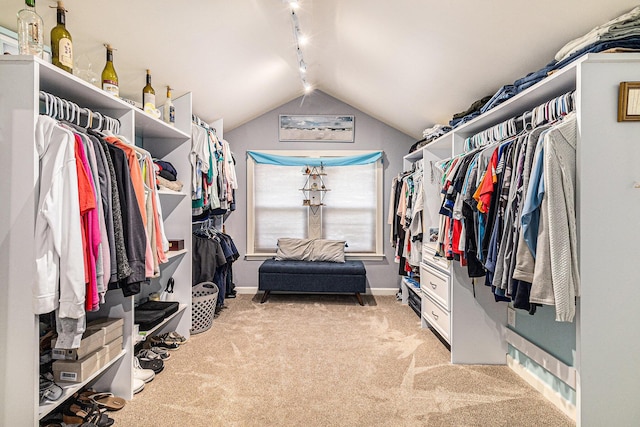 spacious closet featuring light colored carpet and vaulted ceiling