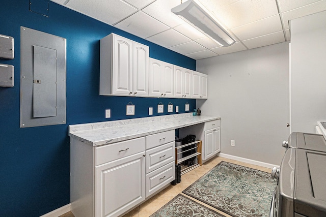 washroom featuring electric panel, baseboards, and light tile patterned floors