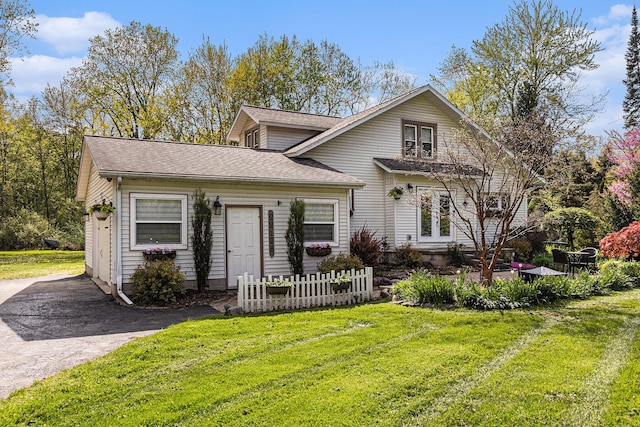 view of front of home featuring a front lawn, a shingled roof, and french doors