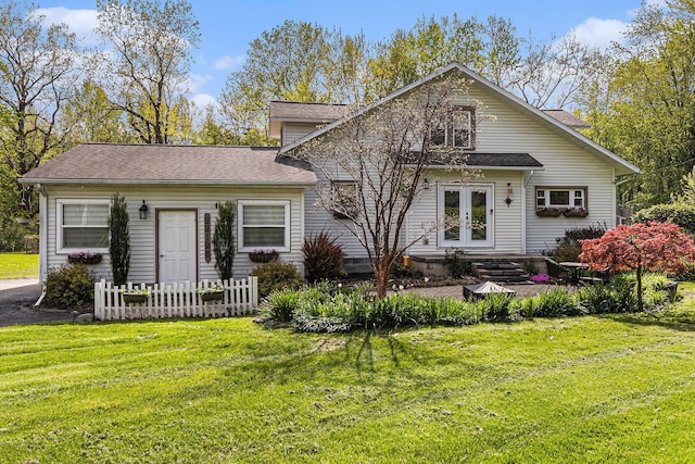 view of front of house featuring french doors, a front yard, and roof with shingles