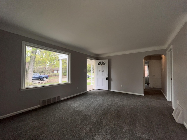 9960 Tecumseh, Redford, MI 48239 - unfurnished living room featuring arched walkways, dark colored carpet, and baseboards