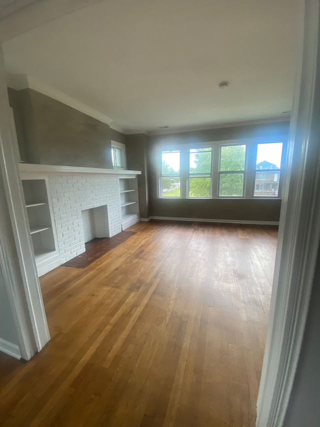 2135 Lakewood St, Detroit, MI 48215 - unfurnished living room with hardwood / wood-style flooring, built in features, and baseboards