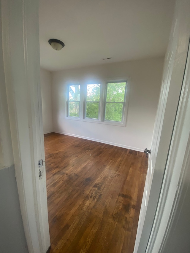 2135 Lakewood St, Detroit, MI 48215 - empty room featuring dark wood-style flooring, plenty of natural light, and baseboards