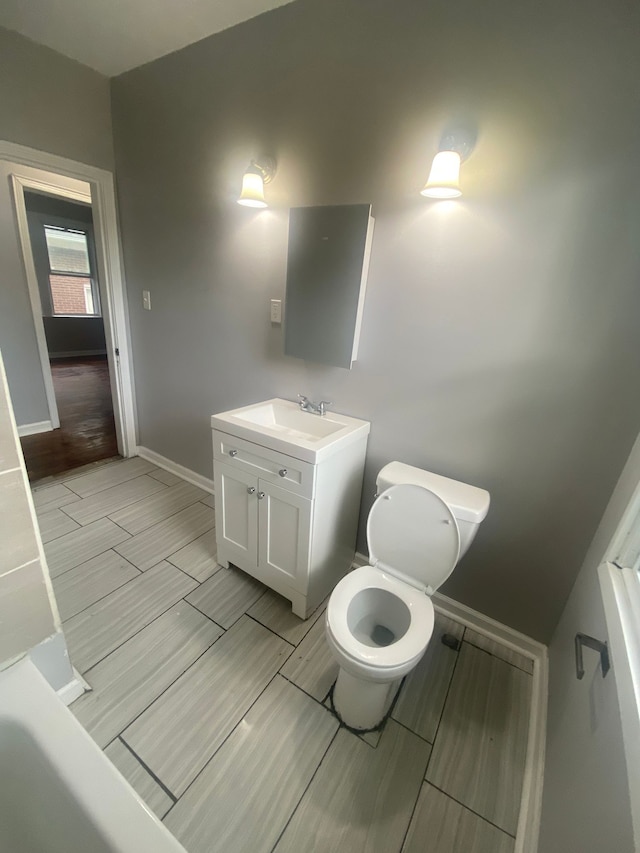 2135 Lakewood St, Detroit, MI 48215 - bathroom featuring vanity, baseboards, toilet, and wood finish floors
