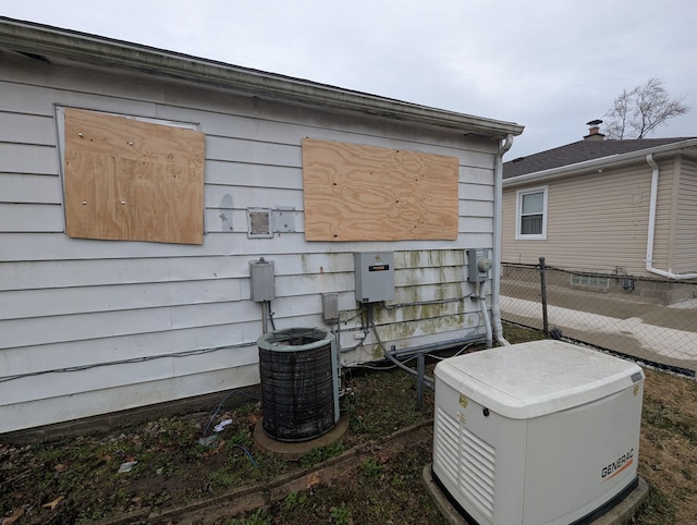 exterior view of a power unit, fence, central AC unit, electric meter, and a downspout