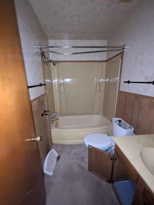 bathroom featuring bathing tub / shower combination, vanity, wainscoting, and toilet