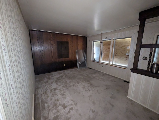 unfurnished living room with wooden walls and wallpapered walls