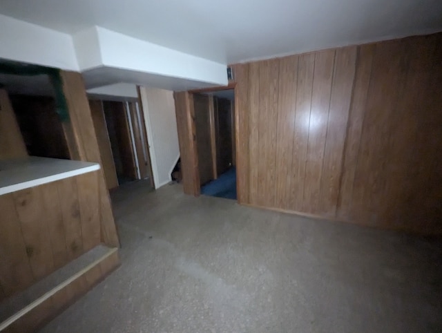 finished basement featuring wood walls and stairway