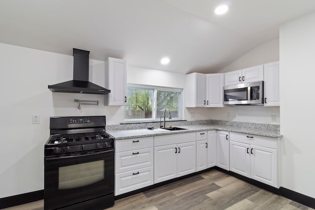 19178 Sherwood St, Detroit, MI 48234 - kitchen featuring black gas range, wall chimney range hood, stainless steel microwave, a sink, and lofted ceiling