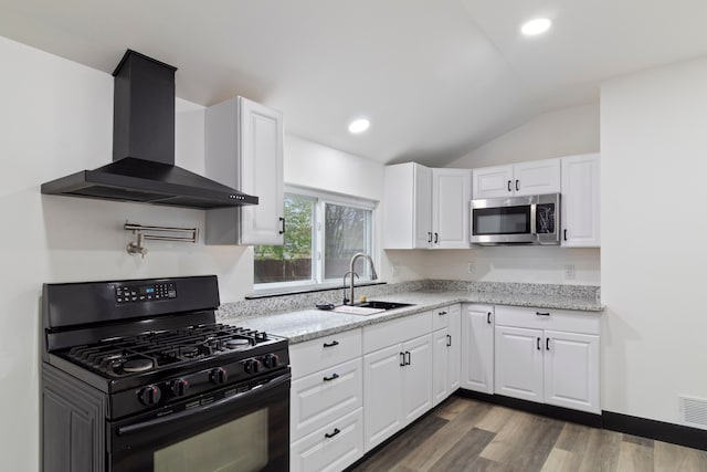 19178 Sherwood St, Detroit, MI 48234 - kitchen with black gas range oven, stainless steel microwave, wall chimney range hood, vaulted ceiling, and a sink