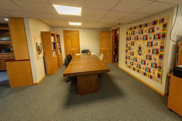 office featuring a paneled ceiling, carpet floors, and baseboards