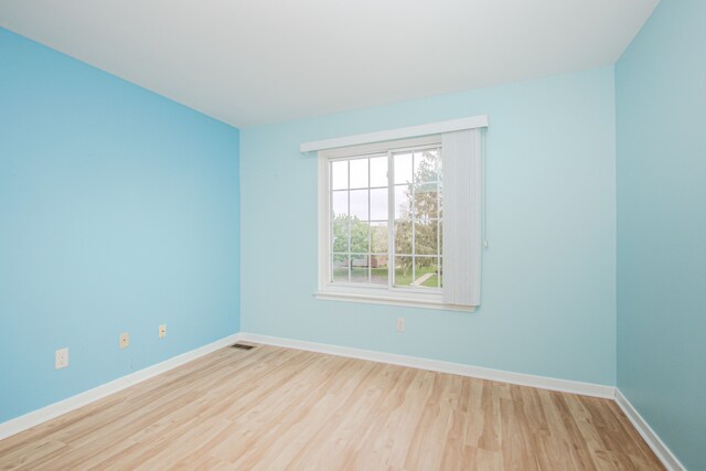 spare room featuring wood finished floors and baseboards