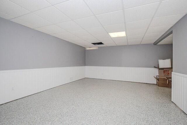unfurnished room with a wainscoted wall and a paneled ceiling