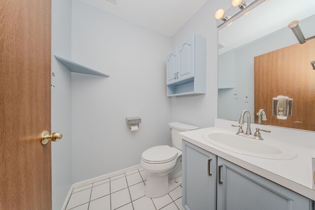 half bath with tile patterned floors, toilet, vanity, and baseboards