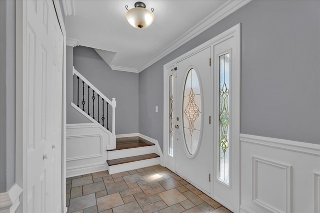 entryway featuring stairs, crown molding, and stone finish floors