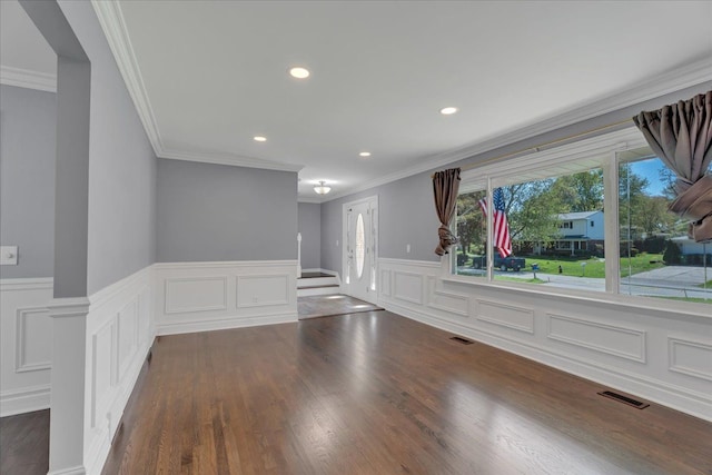 spare room with wainscoting, wood finished floors, crown molding, recessed lighting, and a decorative wall