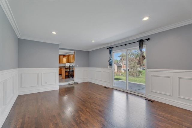 unfurnished living room with wainscoting, dark wood finished floors, recessed lighting, and crown molding