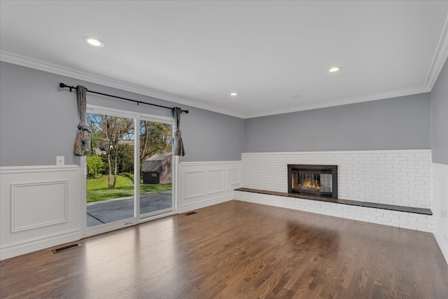 unfurnished living room with wainscoting, a fireplace, wood finished floors, recessed lighting, and ornamental molding