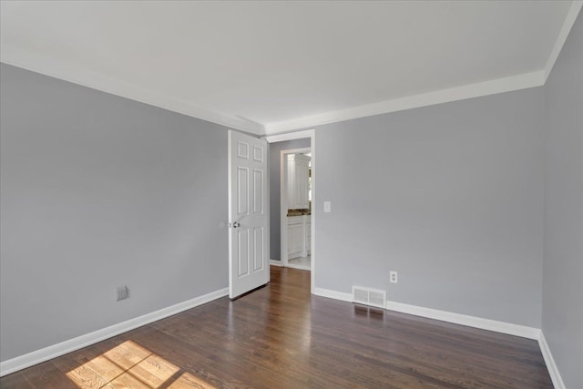 unfurnished room featuring baseboards and wood finished floors
