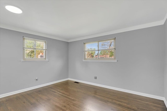 unfurnished room with baseboards and dark wood-type flooring